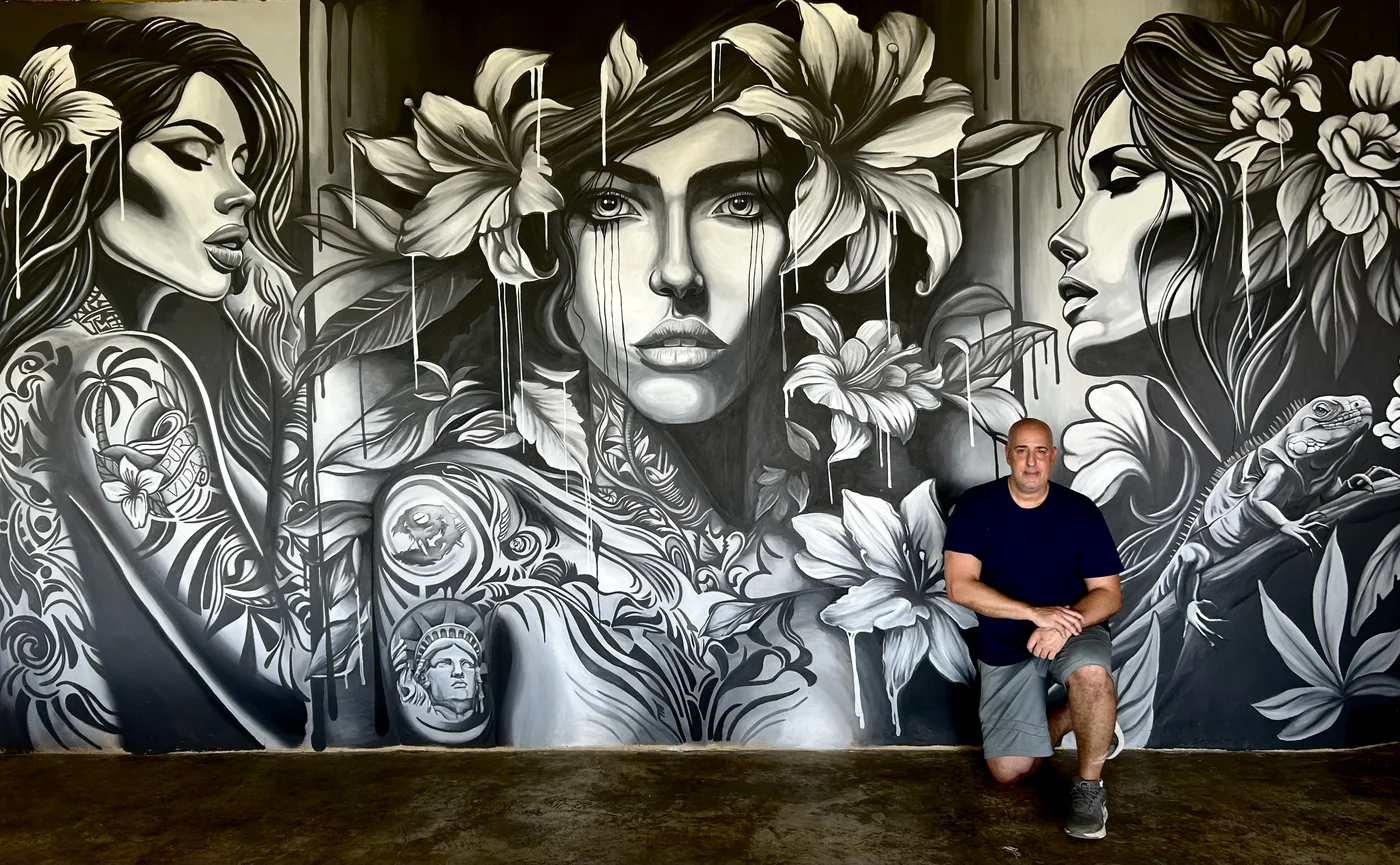 Advanced black and white floral mural at Casa Lamia Resort, Costa Rica, with the artist seated