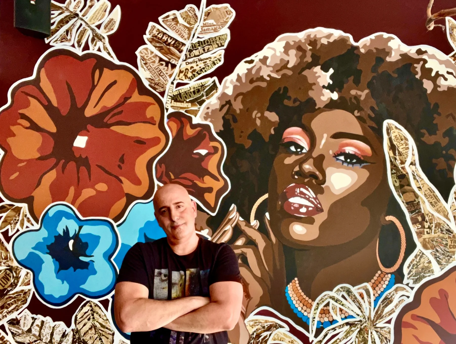 Anthony Scotto standing in front of his floral portrait mural